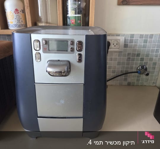 מכונת מים על משטח מטבח עם מדפים מאחוריה